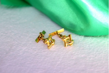 Botões de punho em ouro em forma de cardinal e barretes recortadas.